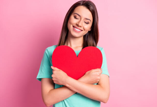 赤いハートを抱える女性